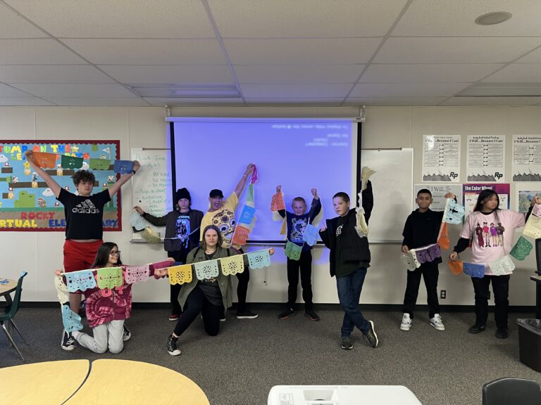 Students hold up their Papel Picado projects