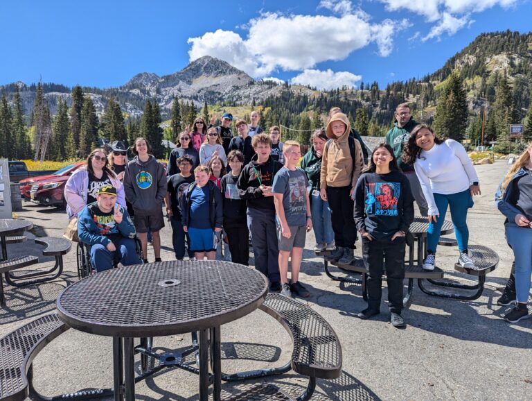 Students stand for a picture in front of a beautiful Mountain